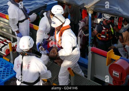 Mittelmeer, 17 Meilen vor der Küste Libyens, 12. Juli 2016. Eine humanitäre Gruppe erholte sich die Leichen von vier Migranten und rettete rund 400 Überlebende am Dienstag aus einem überfüllten Holzboot im Mittelmeer auf dem Weg nach Italien aus Libyen. Die Toten unter Deck, erstickt, sagte der Malta-basierte Migrant Offshore-Hilfe-Station, deren Rettungsschiff der Operation durchgeführt. Bildnachweis: Adam Alexander/Alamy Live-Nachrichten Stockfoto