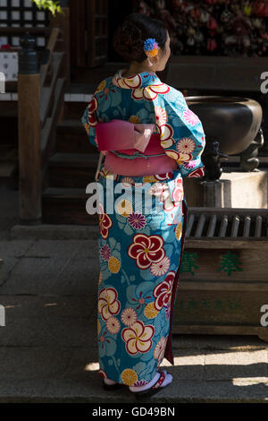 Ein Tourist in einem traditionellen japanischen Kimono besucht eines der Tempel im Stadtteil Higashiyama (alte Stadt) des Kyoto-Protokolls. Stockfoto