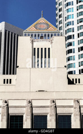 Ein Mosaik aus bunten Keramik Fliesen schmückt das Pyramidendach auf eine kurze Turm auf Richard J. Riordan Central Library, Sitz für die Los Angeles Public Library System in Los Angeles, Kalifornien, USA. Eine symbolische Sonne erscheint auf allen vier Seiten der Pyramide, gekrönt von einer Hand mit einer Fackel darzustellen "The Light of Learning."  Unterhalb des Turmes Brüstung auf einer Fassade sind modellierte Büsten berühmter Denker, darunter Kaiser Justinian, Virgil, Sokrates und Leonardo da Vinci. Architekt Bertram Goodhue entworfen, das Wahrzeichen Art-Deco-Gebäude, das im Jahr 1926 eröffnet. Stockfoto