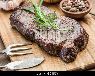 Rib-Eye Steak mit Gewürzen auf dem Tablett aus Holz. Stockfoto