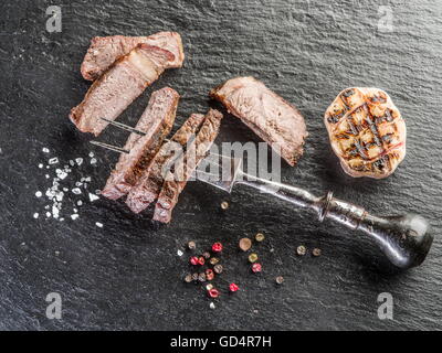 Rib-Eye Steak mit Gewürzen auf dem Graphit-Brett. Stockfoto