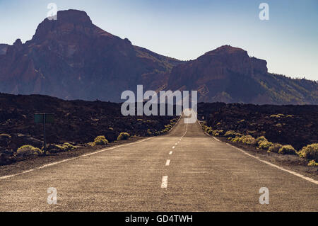 Gerade leer Wüstenstraße mit Berge im Dunst auf Hintergrund, Teneriffa, Kanarische Inseln, Spanien Stockfoto