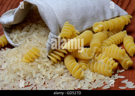 Reiskoerner Holzloeffel und Spiralnudeln, Reiskorn, Reiskoerner, Fusilli, ungekocht Stockfoto