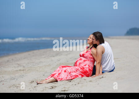 Das schwangere paar umarmt am Strand, Sommerzeit Stockfoto