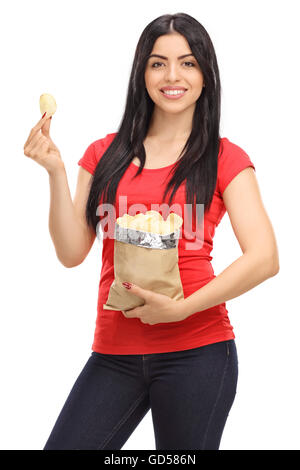 Vertikale Aufnahme einer jungen Frau Essen Kartoffelchips aus einem Beutel isoliert auf weißem Hintergrund Stockfoto