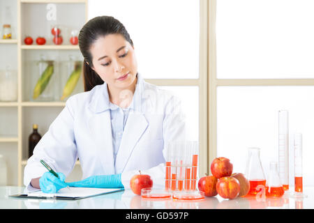 Asiatische Wissenschaftlerin Aufnahme Forschungsdaten für gentechnische Veränderung test Stockfoto