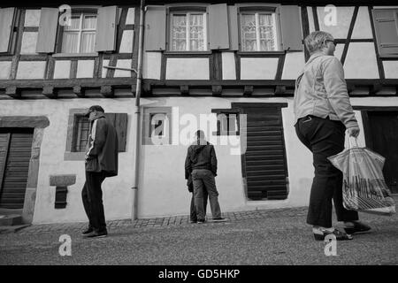 Drei Menschen, die zu Fuß in verschiedene Richtungen vor alten Haus in der Nähe von Paris, Frankreich Stockfoto