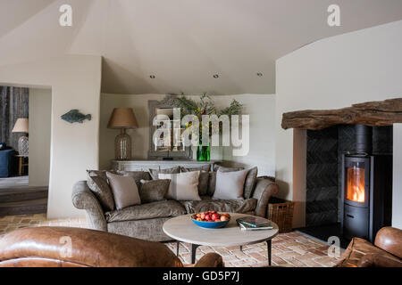 Grauen Sofa gepolstert in Andrew Martin Abingdon samt im Wohnzimmer mit Kaminofen Stockfoto