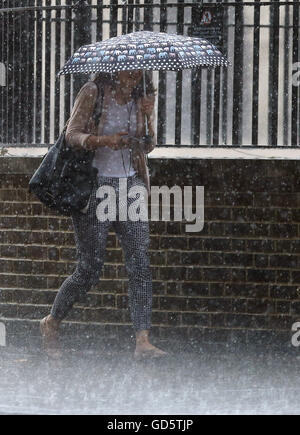 Eine Frau geht durch den Regen aus Horse Guards Parade in Westminster, London. Stockfoto