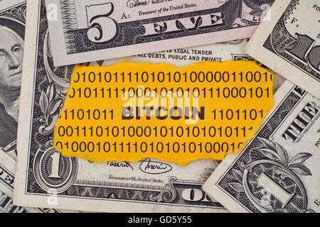 Stück Papier mit dem Wort Bitcoin auf Dollarnoten. Hautnah. Stockfoto