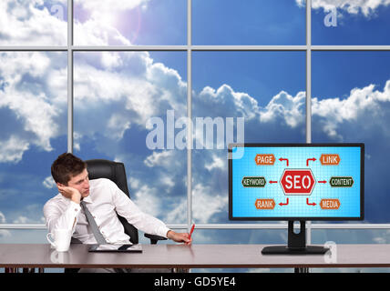 Geschäftsmann sitzt im Büro und auf der Suche, mit Seo-Konzept zu überwachen Stockfoto