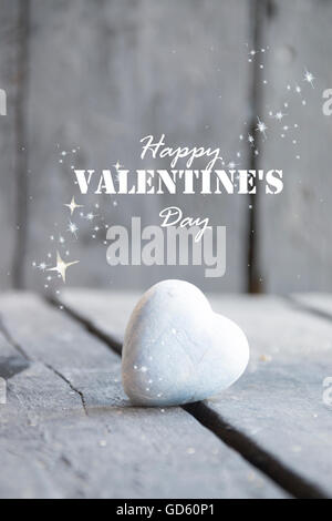 Herz auf einem Holztisch und Happy Valentines Day text Stockfoto