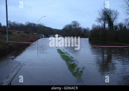 Überflutete Straße blockiert durch eine Kunststoff-Band. Weit im Hintergrund sehen Autos im Wasser stecken. Stockfoto