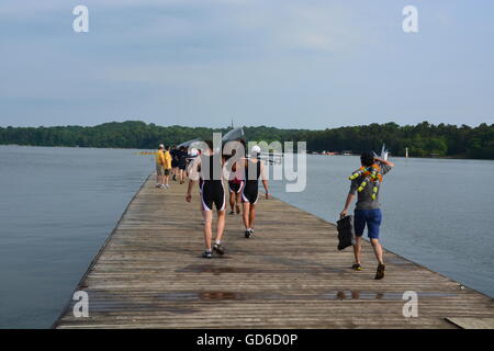 Hochschule rudern Herren Mannschaft tragen ein Boot auf die Station für eine Regatta in Atlanta's ehemaligen Olympiagelände am Lake Lanier im Jahr 2014 zu starten. Stockfoto