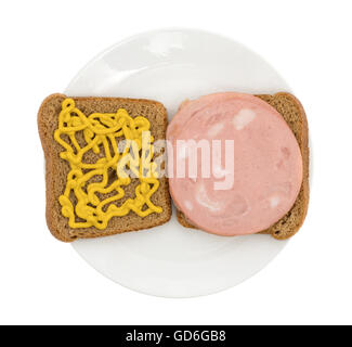 Draufsicht eines Mortadella-Sandwiches in Vollkornbrot mit Senf auf einer Scheibe auf einer Platte öffnen Stockfoto