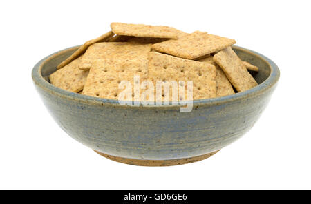 Eine alte Steinzeug Schale gefüllt mit Bio Vollkorn Cracker isoliert auf einem weißen Hintergrund. Stockfoto