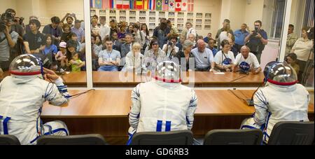 Internationale Raumstation ISS-Expedition 48 Besatzungsmitglieder tragen russische Sokol starten und Eintrag Anzüge sprechen für Familienangehörige von innen isoliert vor dem Start in Baikonur Kosmodrom 7. Juli 2016 in Kasachstan. US-amerikanischer Astronaut Kate Rubens, werden russische Kosmonauten Anatoly Ivanishin und japanische Astronaut Takuya Onishi auf viermonatigen Mission aufbrechen. Stockfoto