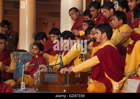 Nicht identifizierte junge Novizen auf Ganga Aarti Zeremonie im Parmarth Niketan Ashram bei Sonnenuntergang. Stockfoto