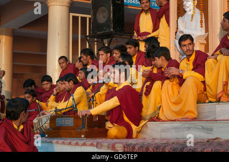 Nicht identifizierte junge Novizen auf Ganga Aarti Zeremonie im Parmarth Niketan Ashram bei Sonnenuntergang. Stockfoto