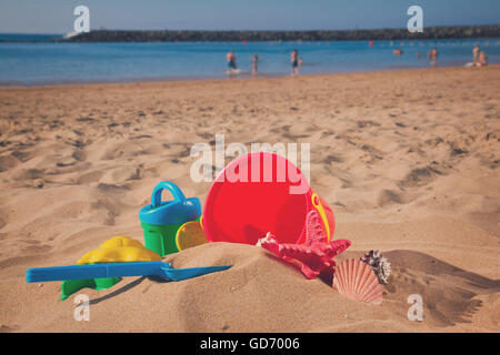 Eimer mit Kunststoff Strandspielzeug im sand Stockfoto