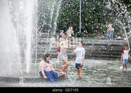 New Yorker und Besucher genießen das Mikroklima am Brunnen im Washington Square Park in Greenwich Village in New York auf Donnerstag, 7. Juli 2016 erstellt. Temperaturen werden voraussichtlich in den hohen 90er Jahren F für den zweiten Tag heute und morgen sein. Drei 90 Grad oder über Tage hintereinander ist offiziell eine Hitzewelle. (© Richard B. Levine) Stockfoto