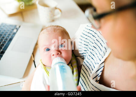 Nicht erkennbare Mutter Fütterung Baby Sohn, Milch in der Flasche, Nahaufnahme Stockfoto