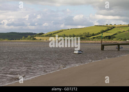 Seelandschaft mit einem kleinen Boot und grünen Hügel in einer ländlichen Landschaft.  Der Strand Ferryside Carmarthenshire Wales Stockfoto