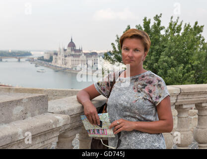 Kaukasische mittlere gealterte Frau touristischen Closeup mit Karte gegerbt. Parlamentsgebäude in Budapest, Ungarn im Hintergrund. Stockfoto