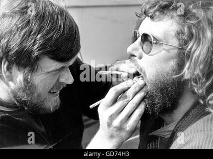 AJAX-NEWS-FOTOS. 30. APRIL 1974. PORTSMOUTH, ENGLAND. -WHITBREAD ROUND THE WORLD RACE - (L-R) GERT FINDEL VON DÜSSELDORF, STUDENT ZAHNARZT AN BORD DER DEUTSCHEN YACHT PETER VON DANZIG, ZEIGT, WIE ER WÄHREND DER LETZTEN ETAPPE DES RENNENS ZÄHNE YACHT 9 CREW IN EINEM GUTEN ZUSTAND GEHALTEN. MEERSCHWEINCHEN IST CREWMAN TOMAS REUTHER, STUDENT DER MEDIZIN. FOTO: JONATHAN EASTLAND/AJAX REF: PEO VON DANZIG WRWR 1974 Stockfoto