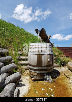 Holz-Kanal und Lauf gemacht in einen Brunnen für sauberes, frisches Quellwasser auf der Seite ein Berg-Wanderweg mit blauem Himmel Stockfoto