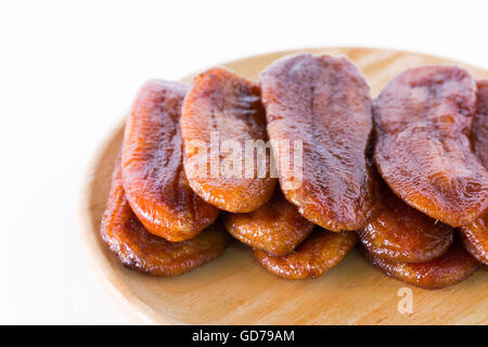 Getrocknete Bananendessert Thailand auf einer Holzplatte auf einem weißen Hintergrund angeordnet. Stockfoto