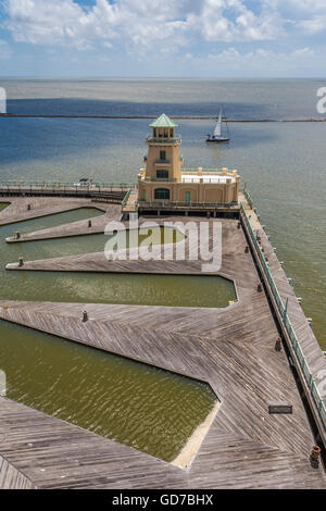 Kleines Segelboot segeln vorbei an der Marina und Leuchtturm im Beau Rivage Resort and Casino auf dem Mississippi Gulf Coast in Biloxi Stockfoto