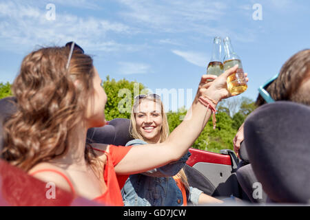 Glückliche Freunde fahren im Cabrio Auto mit Bier Stockfoto