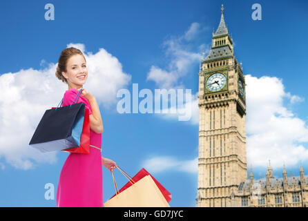 junge glückliche Frau mit Einkaufstüten über big ben Stockfoto