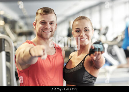 glücklicher Mann und Frau Zeigefinger auf Sie im Fitness-Studio Stockfoto