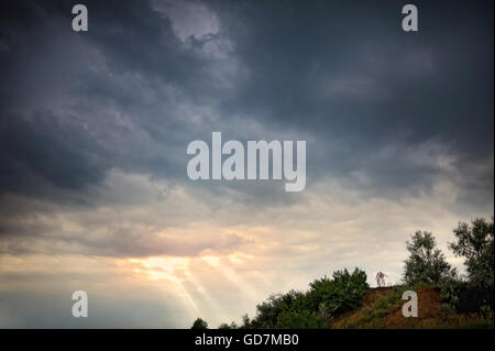 paar in einer Landschaft, Wolken und Sonne Strahl Stockfoto