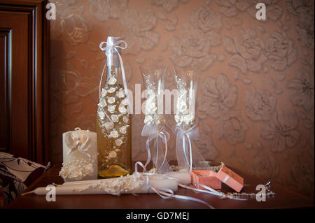 Hochzeit-Gläser und eine Flasche mit weißen Blumen geschmückt Stockfoto