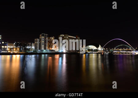 Mit Blick auf den Fluss, von der Stadt in Richtung Newcastle Gateshead, die Lichter von der Ostsee und Brücken sind in den Fluss Tyne wider. Stockfoto