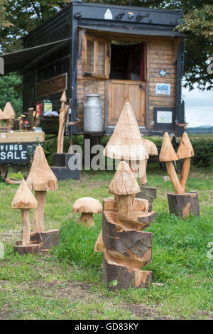 Pilz Holzschnitzereien zu verkaufen vor einem hölzernen Wohnwagen am Straßenrand. Cotswolds, England Stockfoto