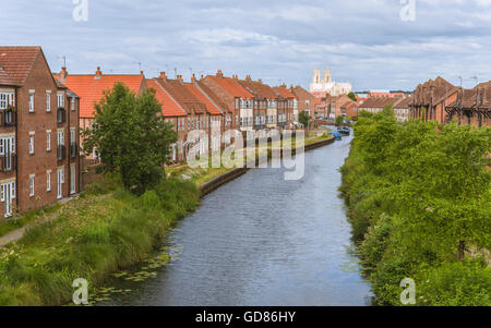 Beck (Kanal) gesäumt von modernen Stadthäusern und Flora mit Blick auf das alte Münster in der Morgendämmerung in Beverley, Yorkshire, Großbritannien. Stockfoto