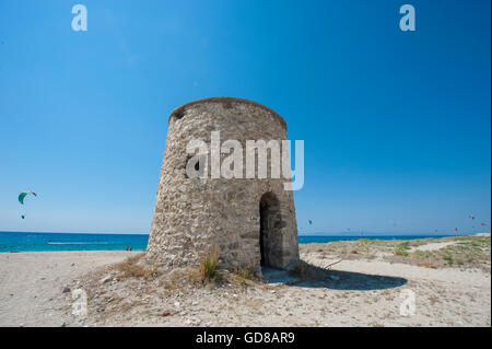 Alte Windmühlen an einem Strand, bevölkert von Windsurfer und Kitesurfer in Lefkada, Lefkas Stockfoto