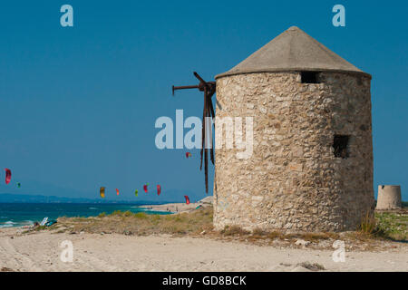 Alte Windmühlen an einem Strand, bevölkert von Windsurfer und Kitesurfer in Lefkada, Lefkas Stockfoto