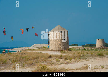 Alte Windmühlen an einem Strand, bevölkert von Windsurfer und Kitesurfer in Lefkada, Lefkas Stockfoto