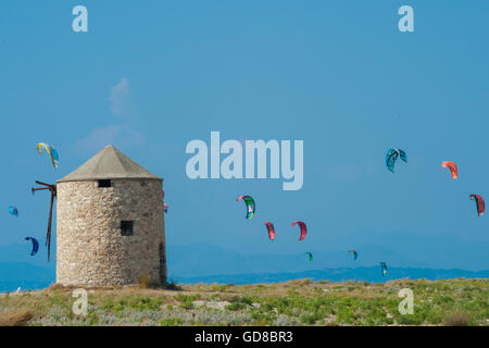 Alte Windmühlen an einem Strand, bevölkert von Windsurfer und Kitesurfer in Lefkada, Lefkas Stockfoto