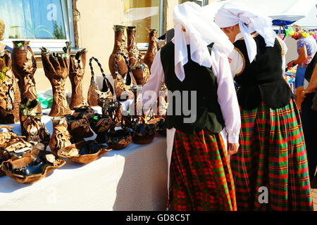 Frauen in der litauischen nationalen Kostüme in der Nähe von Tontöpfen. Stockfoto