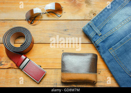 Jeans, Sonnenbrillen und Leder Gürtel Geldbeutel auf den hölzernen Vintage mit Textfreiraum Stockfoto