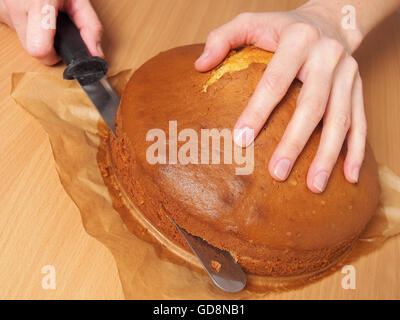 Schneiden Kuchen in Schichten. Torte mit Buttercreme-Füllung und geriebener Schokolade Topping machen. Serie. Stockfoto