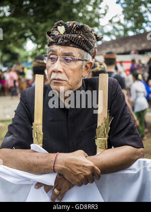 Ubud, Bali, Indonesien. 13. Juli 2016. Ein Mann an die Masse Einäscherung in Ubud Mittwoch. Menschen vor Ort in Ubud die Überreste von Familienmitgliedern exhumiert und verbrannt ihre Überreste in einer Masse Einäscherung Zeremonie Mittwoch. Fast 100 Menschen werden verbrannt und in die größte Masse Einäscherung in Bali in Jahren diese Woche bestattet. Die meisten Menschen auf Bali sind Hindus. Traditionelle Feuerbestattungen in Bali sind sehr teuer, so dass die Gemeinden in der Regel eine Masse Einäscherung etwa alle fünf Jahre halten. Bildnachweis: ZUMA Press, Inc./Alamy Live-Nachrichten Stockfoto