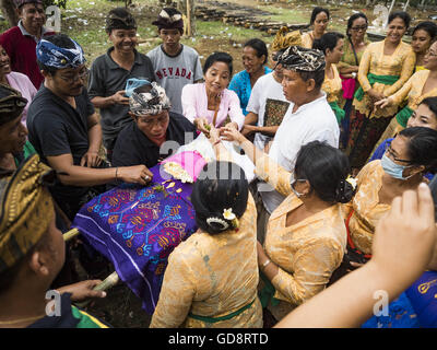 Ubud, Bali, Indonesien. 13. Juli 2016. Die verbrannten Knochen von einem Mitglied der Gemeinschaft sind nach seiner Einäscherung gewickelt. Menschen vor Ort in Ubud die Überreste von Familienmitgliedern exhumiert und verbrannt ihre Überreste in einer Masse Einäscherung Zeremonie Mittwoch. Fast 100 Menschen werden verbrannt und in die größte Masse Einäscherung in Bali in Jahren bestattet. Die meisten Menschen auf Bali sind Hindus. Traditionelle Feuerbestattungen in Bali sind sehr teuer, so dass die Gemeinden in der Regel eine Masse Einäscherung etwa alle fünf Jahre halten. Bildnachweis: ZUMA Press, Inc./Alamy Live-Nachrichten Stockfoto