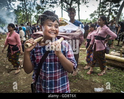 Ubud, Bali, Indonesien. 13. Juli 2016. Ein Junge trägt die verbrannten Knochen von einem Mitglied der Gemeinschaft nach der Masse Einäscherung Ceremon. Menschen vor Ort in Ubud die Überreste von Familienmitgliedern exhumiert und verbrannt die Überreste von 100 Menschen. Traditionelle Feuerbestattungen in Bali sind sehr teuer, so dass die Gemeinden in der Regel eine Masse Einäscherung etwa alle fünf Jahre halten. © Jack Kurtz/ZUMA Draht/Alamy Live-Nachrichten Stockfoto